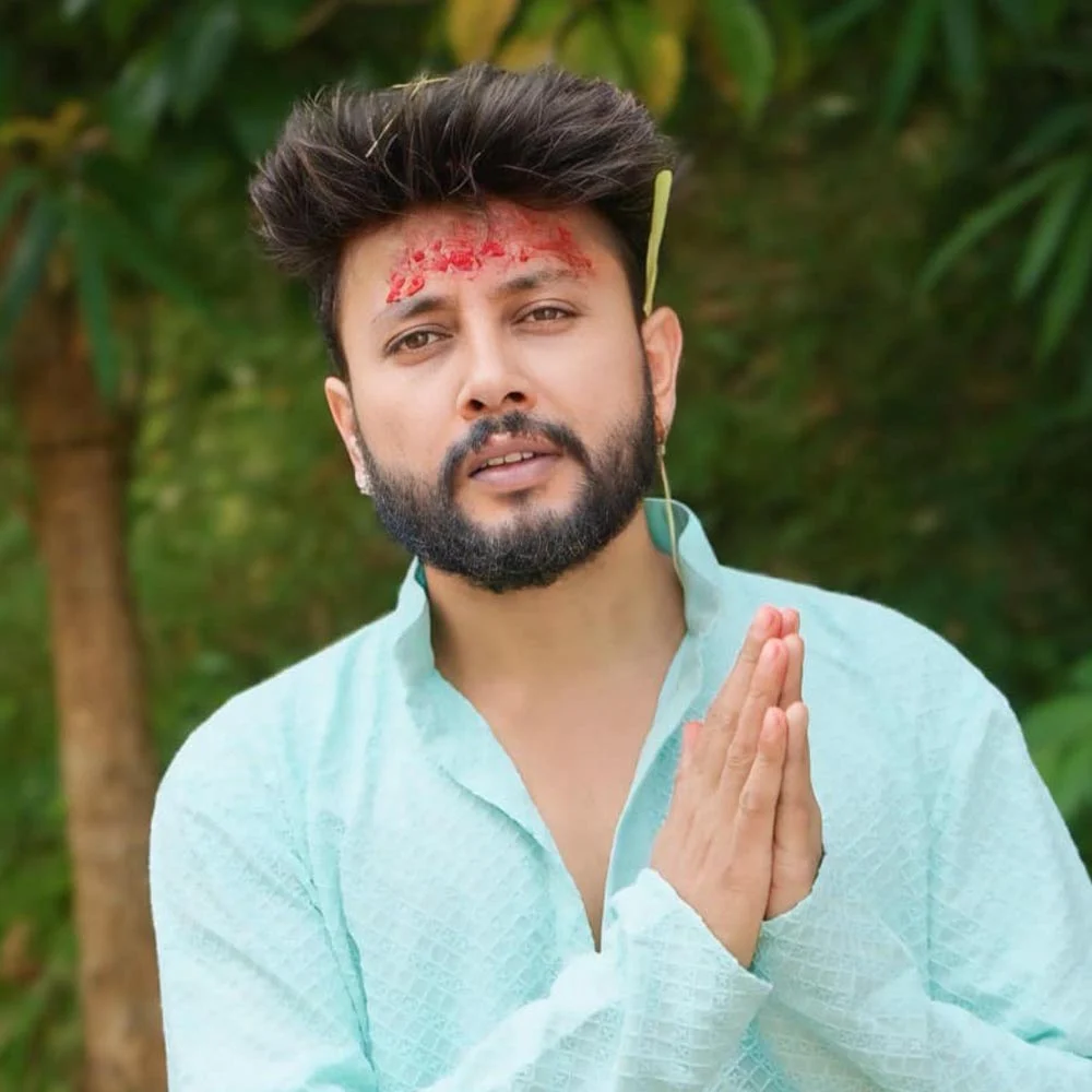 Nepali pop-folk singer Durgesh Thapa smiling and posing outdoors wearing traditional attire during a cultural festival